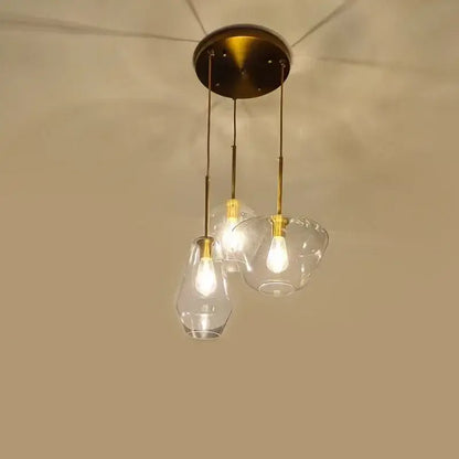 Brass-finished pendant light with three clear glass shades ideal for kitchen glass chandelier lighting
