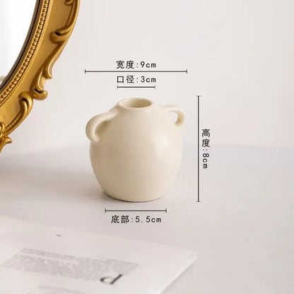Cream-colored ceramic candle holder with two small handles and rounded body from decorbites geometric ceramic set