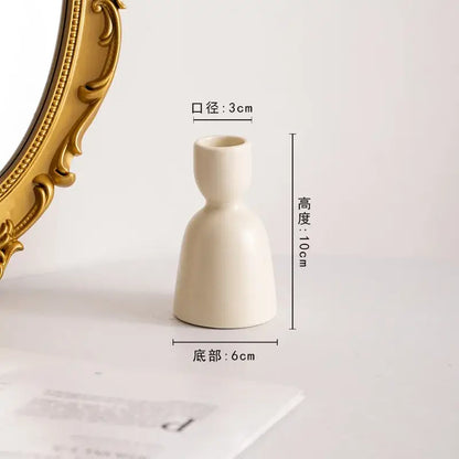 Cream-colored ceramic candle holder with slender neck and flared base for decorbites geometric ceramic candle set