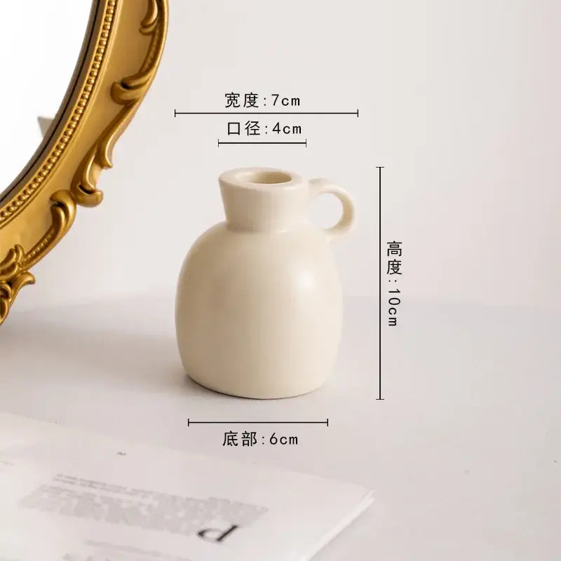 Cream-colored geometric ceramic candle holder with rounded body narrow neck small handle for living room decorbites decor