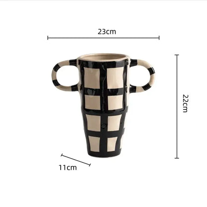 Black and cream ceramic vase with geometric check pattern and two looped handles for living room decor