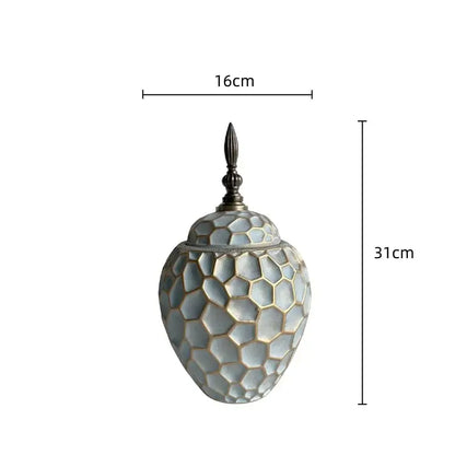 A 31cm tall light gray ceramic vase with geometric diamond check honeycomb pattern and ornate dark metal lid