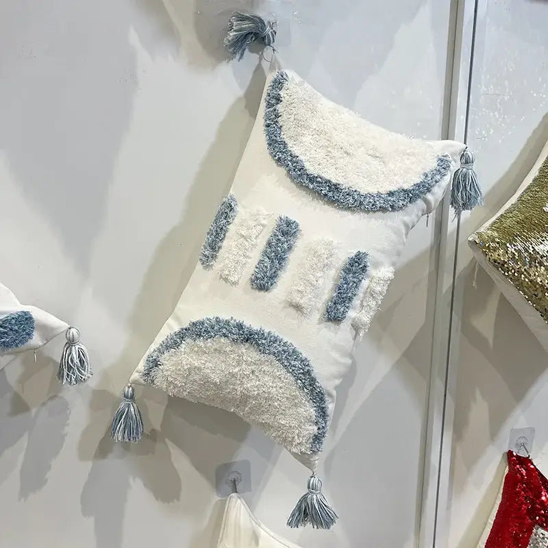 White rectangular pillow with geometric diamond tufted embroidery and blue and white textured fringe decorbites geometric diamond