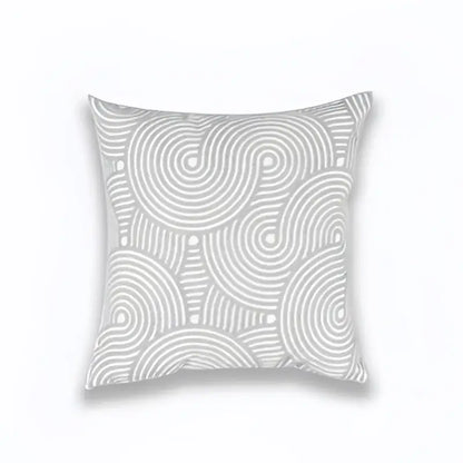 A square light grey cotton cushion cover with geometric embroidered white swirls and dots for living room decor