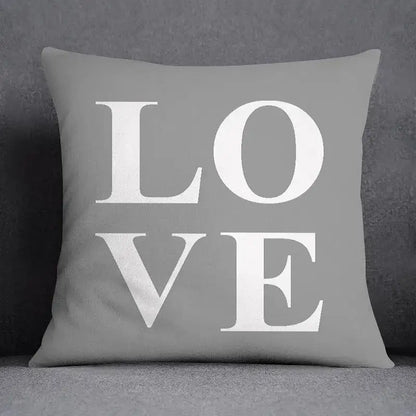 Gray throw pillow case with bold white love lettering featuring decorbites geometric floral print for living room decor