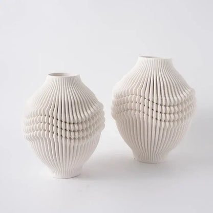 Two off-white geometric folding ceramic vases with intricate ribbed textures for living room decor by decorbites