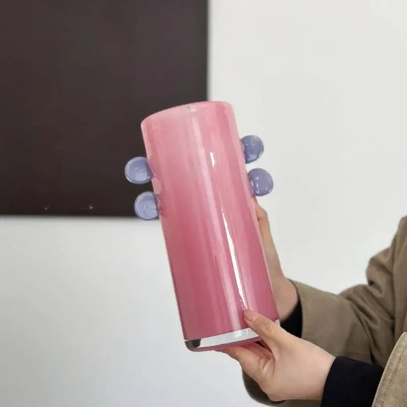 Pink cylindrical tumbler with glossy finish and four purple suction cups as decorbites geometric glass vase with color patches