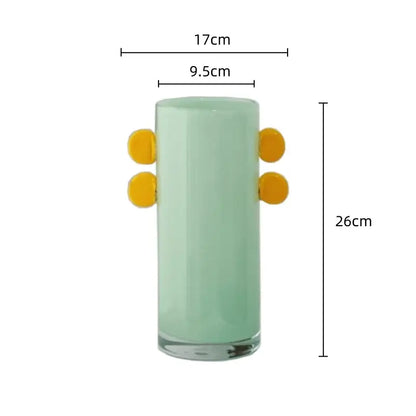 A tall translucent mint green geometric glass vase with bright yellow color patches for living room decorbites decor