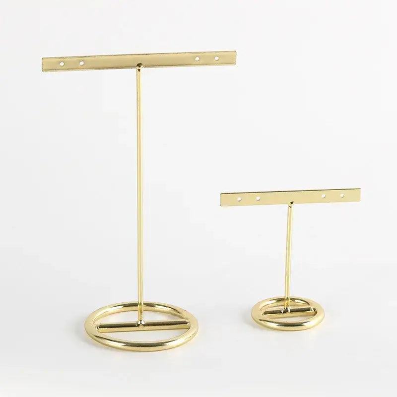 Geometric gold jewelry display rack with gold metal earring stands featuring circular bases and adjustable holes