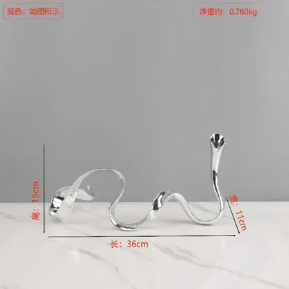 Silver sleekly curved metal candlestick holder with a modern abstract design for decorbites geometric gold dining room centerpiece