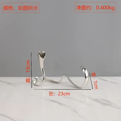 Silver metallic candlestick holder with sleek sculpted curves and open top for decorbites geometric gold dining centerpiece