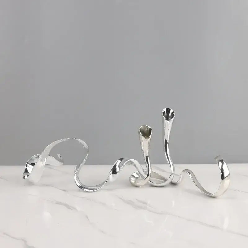 Silver abstract twisted metal candlestick holder with smooth reflective surfaces in decorbites geometric gold centerpiece