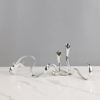 Silver abstract twisted metal candlestick holder with smooth reflective surfaces in decorbites geometric gold centerpiece
