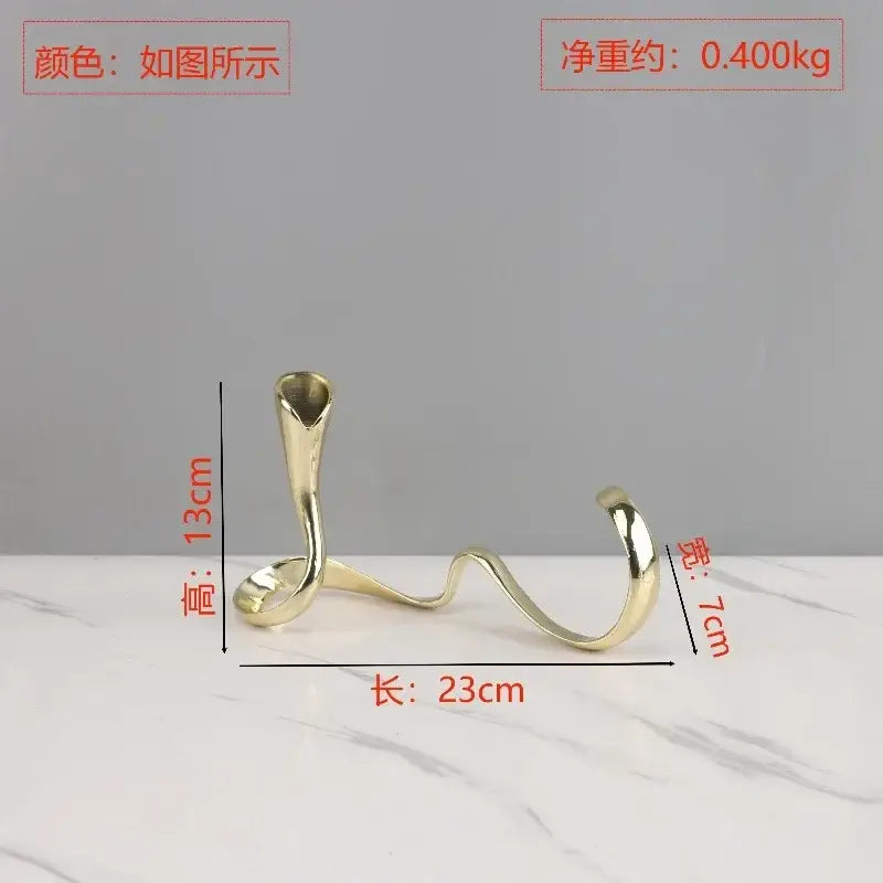 A sleek gold-toned metal candlestick holder with an elegant twisted design for decorbites geometric gold centerpiece