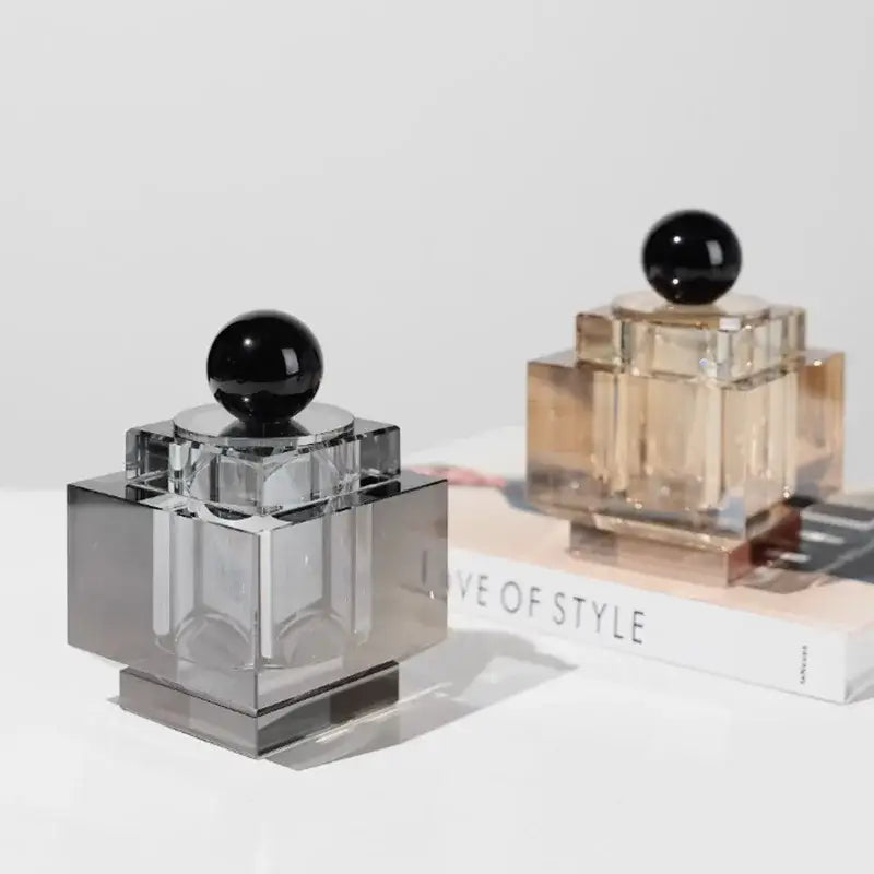 Two geometric storage jars with gold and silver crystal bases and black spherical caps for bedroom jewelry box use