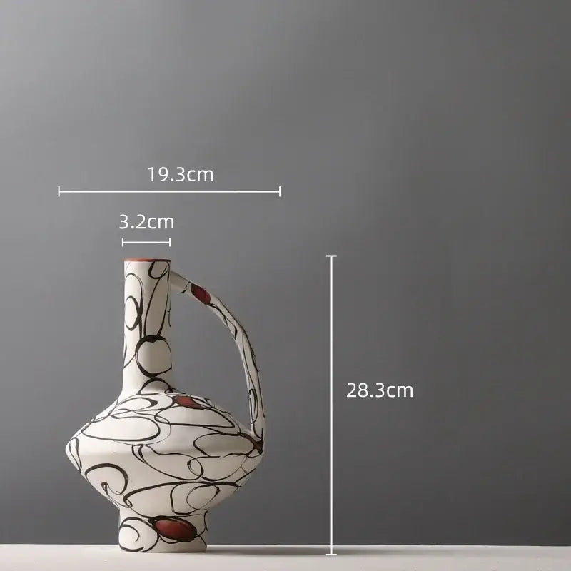 A white ceramic geometric graffiti vase with slender neck, curved handle, and black swirls for terracotta decorbites decor