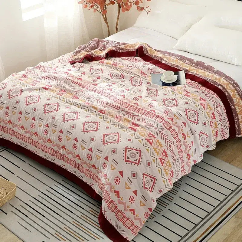 A decorbites cotton gauze geometry summer blanket with white base, red and gray geometric designs, and burgundy border