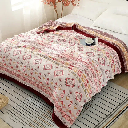 A decorbites cotton gauze geometry summer blanket with white base, red and gray geometric designs, and burgundy border