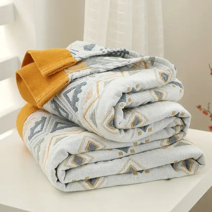 A cozy gray and mustard cotton gauze geometry summer blanket with geometric pattern and soft fleece lining by decorbites
