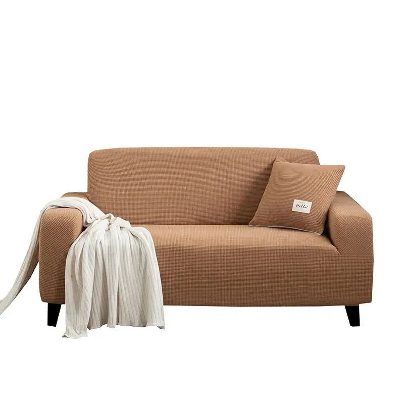 Tan textured fabric sofa cover with matching pillow and cream throw blanket for living room use
