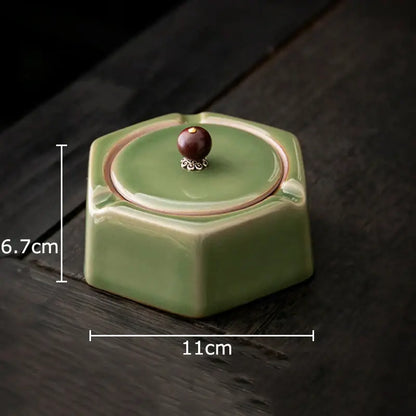 Geometric green ceramic ashtray with lid featuring a hexagonal shape and dark brown knob with silver detailing for office decorbites decor