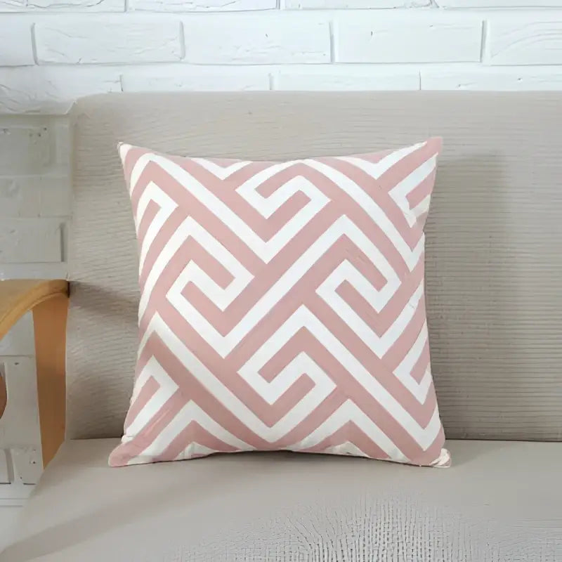 A square cushion cover in decorbites grey pink with soft pink and white geometric embroidery on textured fabric