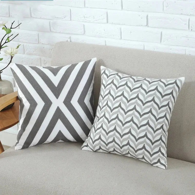Two square cushion covers with grey pink geometric patterns featuring chevron and wavy zigzag designs for decorbites living room decor