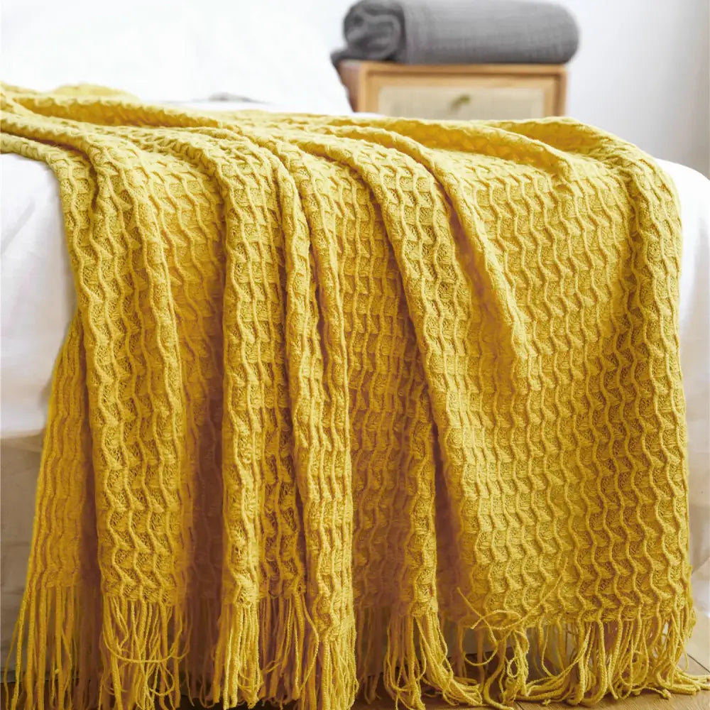 Cozy mustard-yellow decorbites geometric knit sofa blanket with textured waffle pattern and fringed tassel edges