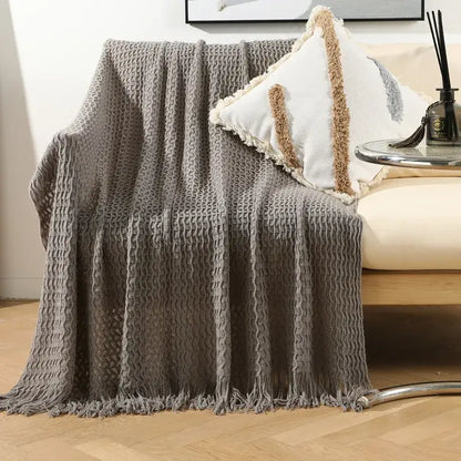 Gray textured knit sofa blanket with fringed edges and cozy woven pattern from decorbites geometric knit collection