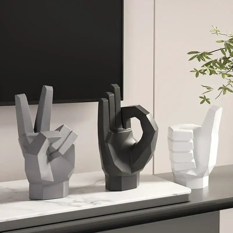 Three geometric hand gesture art decor sculptures in matte gray black and white resin for living room display
