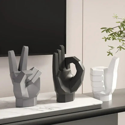 Three geometric hand gesture art decor sculptures in matte gray black and white resin for living room display