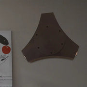 Bronze geometric metallic shade wall sconce featuring a triangular design with central circular plate and holes for corridor or bedroom lighting