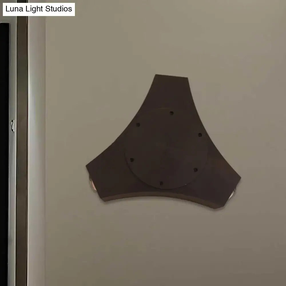Dark gray triangular wall-mounted speaker with circular center and six holes featuring geometric metallic shade design