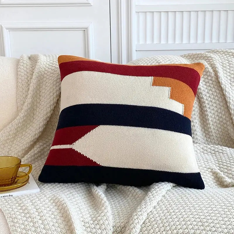 Cozy knitted cushion cover set featuring bold horizontal stripes in cream deep red navy blue and warm orange for living room decor