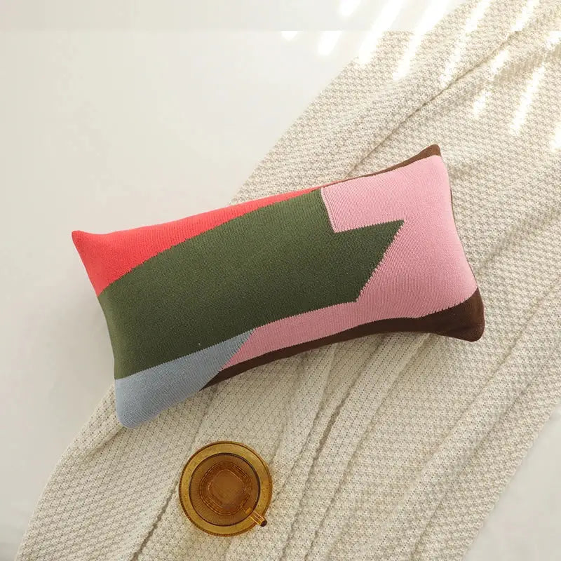 Rectangular knitted cushion cover set with bold coral, olive green, pink, blue, and brown geometric blocks for living room decor