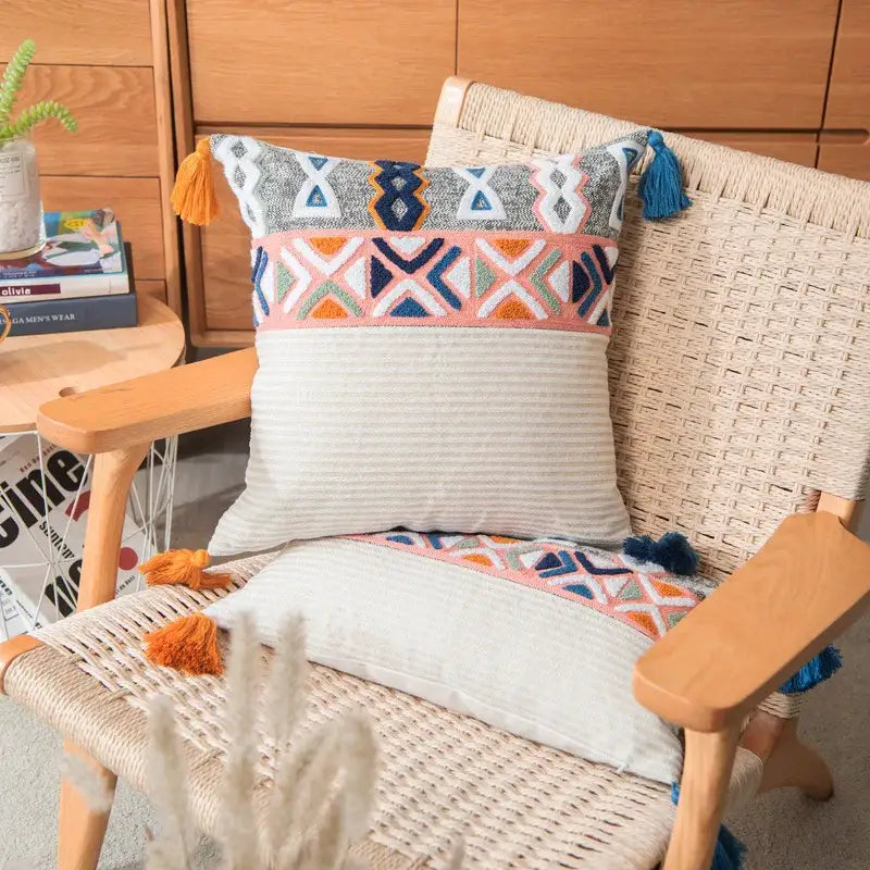 Colorful embroidered cushion cover with navy, orange, and pink geometric patterns and tassels for living room decor