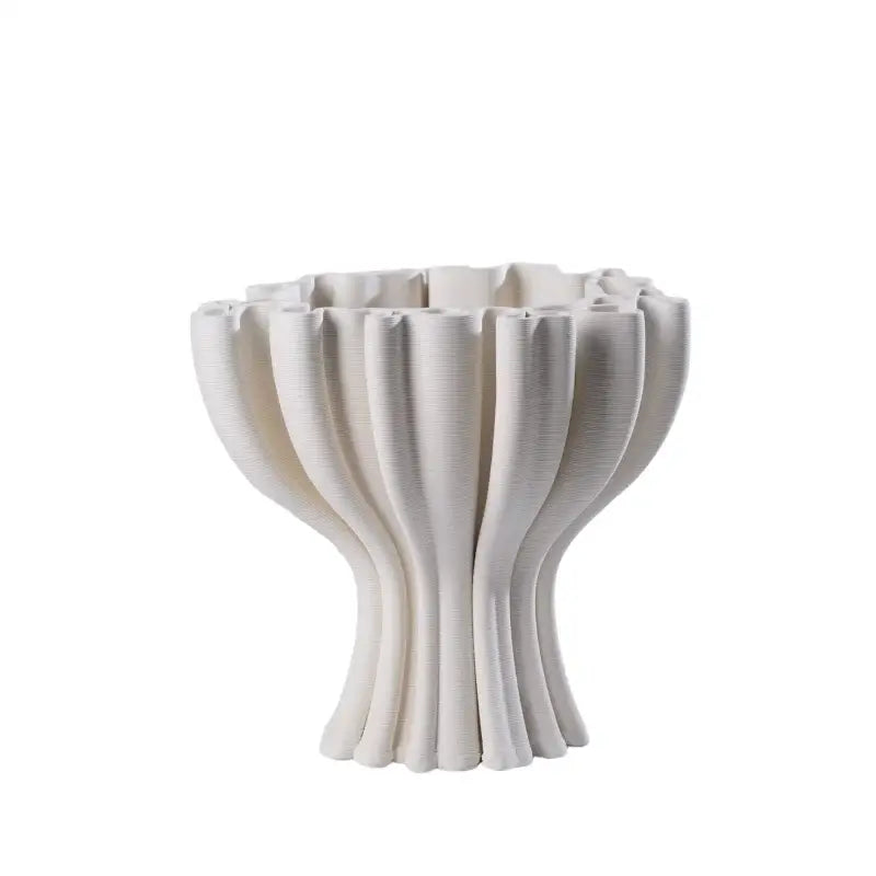 A white ceramic flower pot sculpture with fluted petal rim and ribbed stems for geometric living room decor