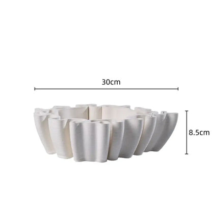 A white ceramic flower pot sculpture with a fluted petal rim and textured surface for living room decor