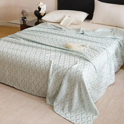 A soft mint green bamboo fiber summer blanket with a subtle gray geometric pattern for lightweight bedding decorbites
