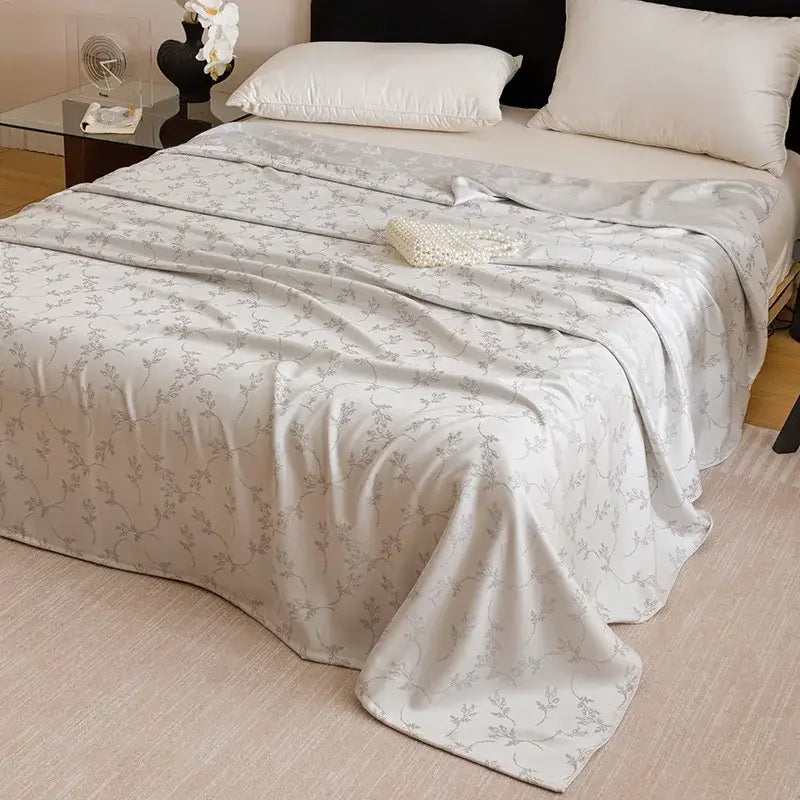 A soft off-white bamboo fiber summer blanket with a delicate gray floral pattern for lightweight bedding decorbites bamboo fiber