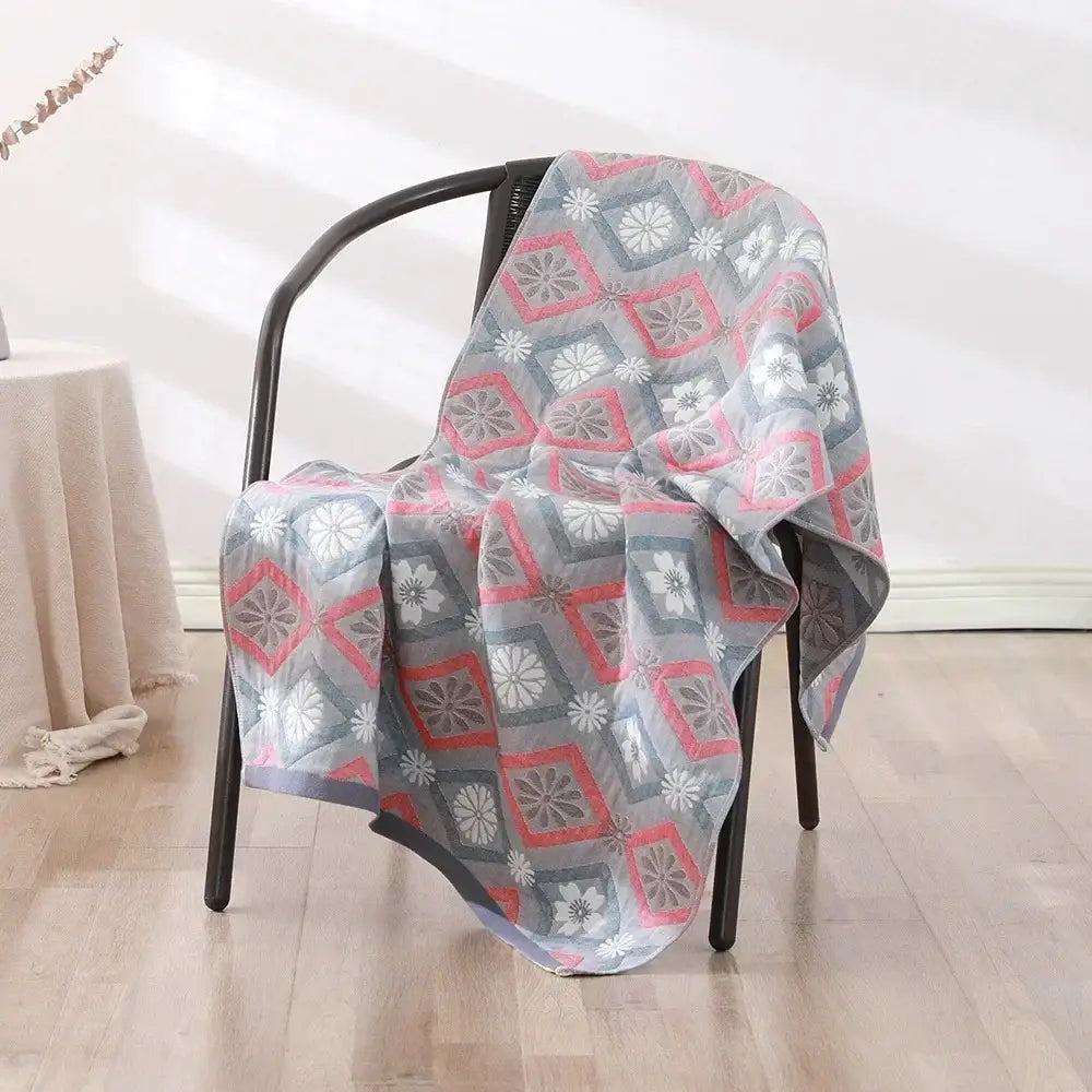 A soft lightweight decorbites cotton bath towel with a pink and gray geometric pattern for quick drying