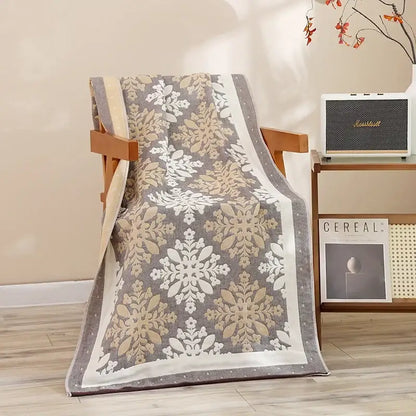 A cozy gray and cream throw blanket with snowflake pattern draped over a wooden chair for decorbites cotton bath towel decor