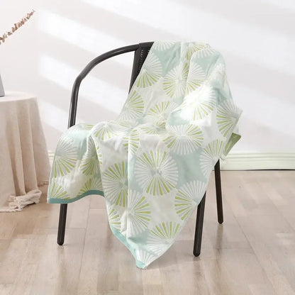 A soft mint green and white decorbites cotton bath towel with fan pattern draped over a black chair for quick dry use