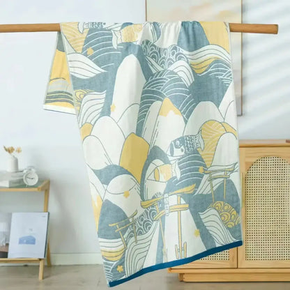 A soft absorbent decorbites cotton bath towel with stylized wave and fish pattern in blue yellow and white