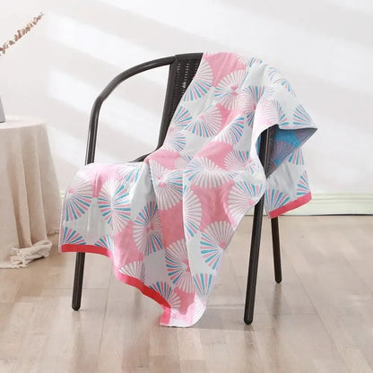 A soft white cotton bath towel with vibrant pink and blue fan pattern and solid pink border for quick dry use