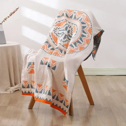 A soft off-white decorbites cotton bath towel with bold orange and gray geometric pattern and embroidered border