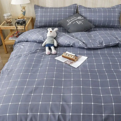 Gray grid-patterned quilt cover set with white lines and matching pillows for a geometric pink and white gingham bedroom