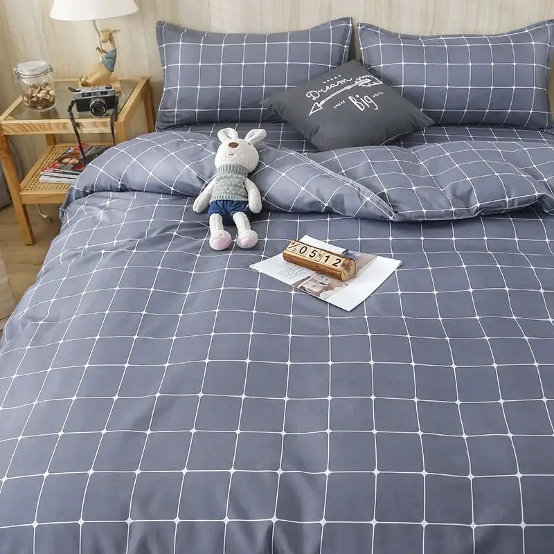 Gray grid-patterned quilt cover set with white lines and matching pillows for a geometric pink and white gingham bedroom