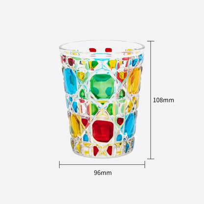 A vibrant glass tumbler with colorful red green and amber gemstone inserts heavy whiskey glass for dining room use