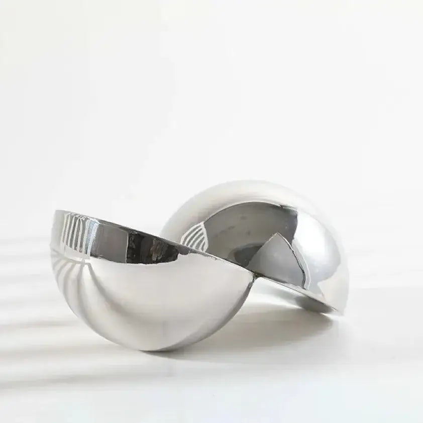 Shiny silver metallic spherical glass bowl with smooth reflective surface and ridged edge as home decor figurine